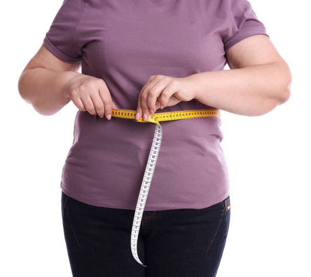 Overweight woman measuring waist with tape on white background, closeup - Φωτογραφία, εικόνα