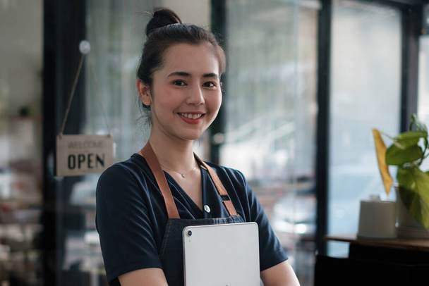 Portret kobiety azjatyckiej barista właściciel kawiarni uśmiech podczas kawiarni otwarte. Koncepcja przedsiębiorstwa sprzedającego MŚP. - Zdjęcie, obraz