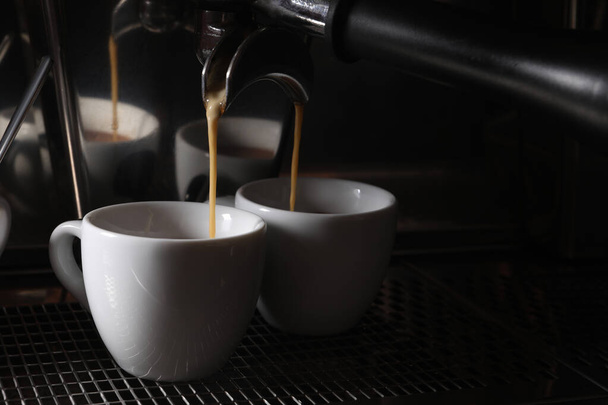 Making fresh aromatic espressos using professional coffee machine in cafe, closeup. Space for text - Фото, зображення
