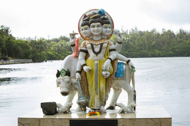 Posąg lordów Brahmy, Wisznu i Sziwy nad świętym jeziorem Ganga Talao na południu wyspy Mauritius. - Zdjęcie, obraz