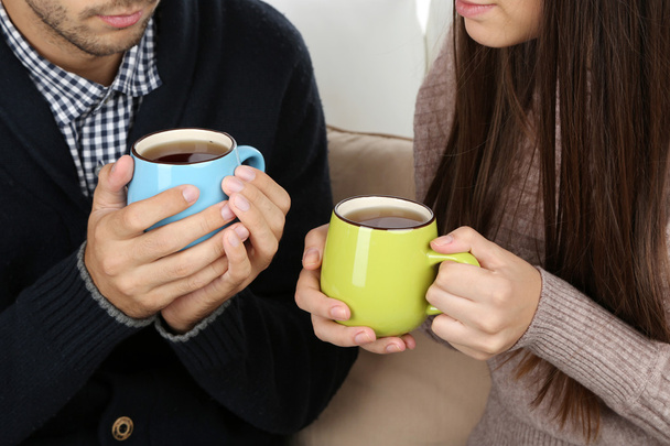Loving couple with hot drinks - 写真・画像