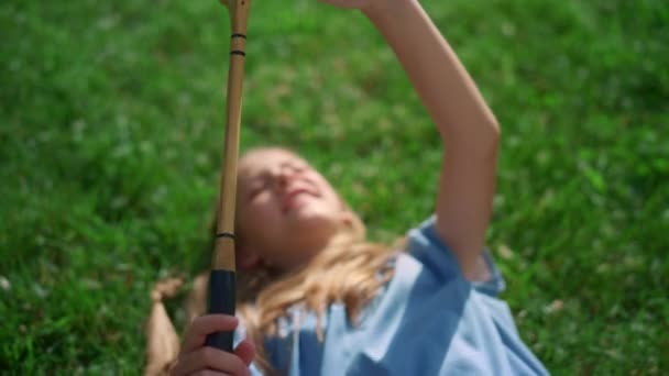 Closeup badminton raquete em mãos de menina alegre sorrindo deitado em cobertor. - Filmagem, Vídeo