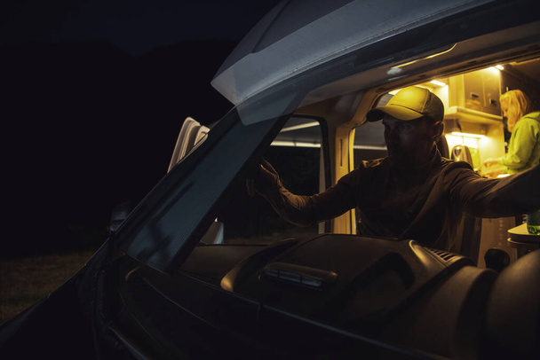 Белый Мужчины в возрасте 40 лет закрывают выдвижной лобовое стекло Motorhome Camper Van Sun Shade For the Night.  - Фото, изображение