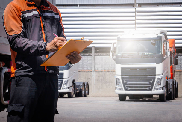A kamionsofőr ellenőrzi a kamion motorkarbantartási listáját. Kamionsofőr. Ellenőrző Teherautó Biztonsági Vezetés. Szállítás Tehergépjármű-szállítás. - Fotó, kép