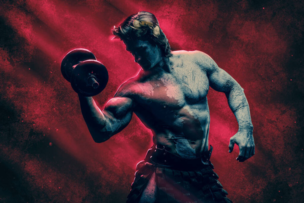 Strong greek man with dumbbell agianst red background - Foto, afbeelding