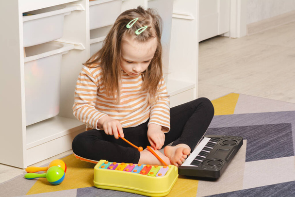 Child at home learning to play musical instruments. Leisure and education at home - Fotoğraf, Görsel