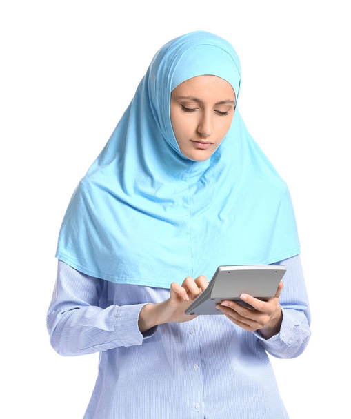 Muslimische Sekretärin mit Taschenrechner auf weißem Hintergrund - Foto, Bild