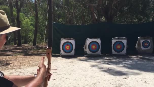 Felnőtt ausztrál férfi (férfi 40-50 éves) íjász célja, hogy cél egy erdőben Ausztráliában. - Felvétel, videó