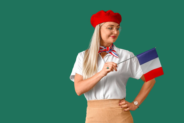 Гарна жінка з прапором Франції на зеленому тлі. - Фото, зображення