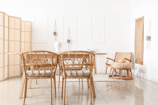 Masası, hasır koltukları ve katlanır perdesi olan hafif yemek odasının içi - Fotoğraf, Görsel