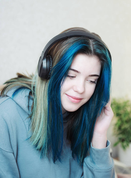 Молода дівчина-підліток з блакитним волоссям і навушниками
  - Фото, зображення