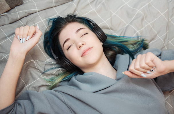 Młoda nastolatka z niebieskimi włosami i słuchawkami  - Zdjęcie, obraz