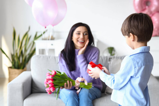 Маленький сын поздравляет свою мать с Международным женским днем дома - Фото, изображение