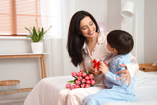 Little son greeting his mother for International Women's day in bedroom at home - Fotoğraf, Görsel