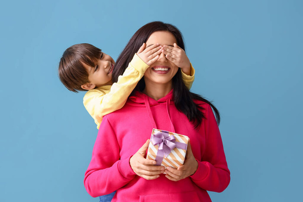 Little son greeting his mother on color background - Photo, Image