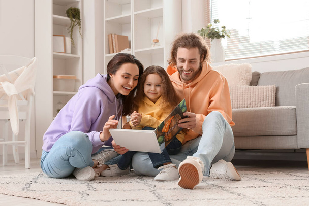 Nuori perhe lukeminen kirja yhdessä kotona - Valokuva, kuva