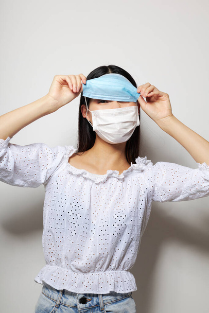 Portrait Asian beautiful young woman two medical masks on the head protection studio model unaltered - 写真・画像
