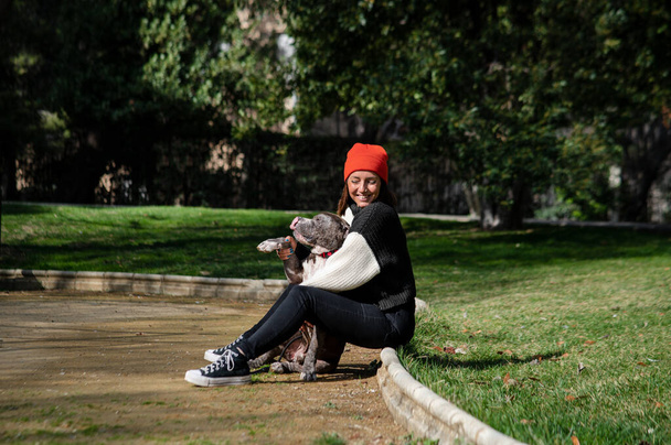 Young girl with her dog in the park in the summertime - Φωτογραφία, εικόνα