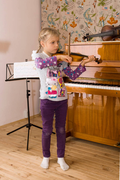 Lekcja muzyki, mały skrzypek uczy się grać na skrzypcach - Zdjęcie, obraz