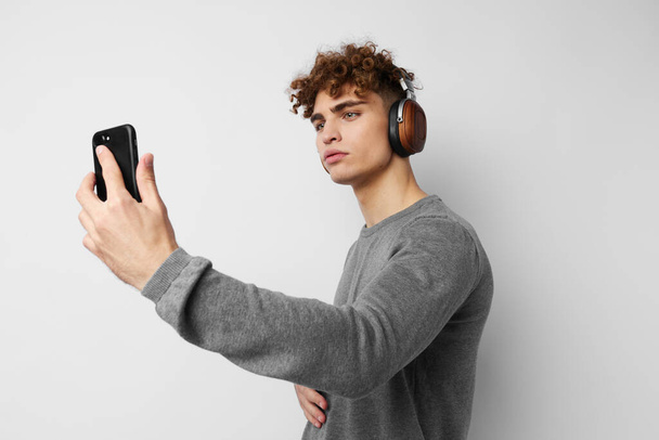 stylish guy looking at the phone headphones fashion Lifestyle unaltered - Foto, Imagem