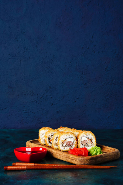 Sushi, tempura bułki Kalifornii z łososiem, krewetki, tuńczyk, kawior i ser na ciemnym tle z miejsca na tekst.. - Zdjęcie, obraz
