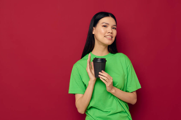 woman with Asian appearance in a green t-shirt a glass of drink fun isolated background unaltered - Fotografie, Obrázek