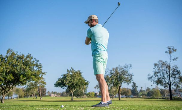männlicher Golfspieler auf dem Golfplatz. Porträt eines Golfers mit Mütze und Golfschläger. - Foto, Bild