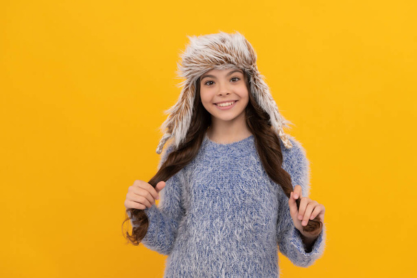 happy kid long hair in hat on yellow background, winter - Photo, Image