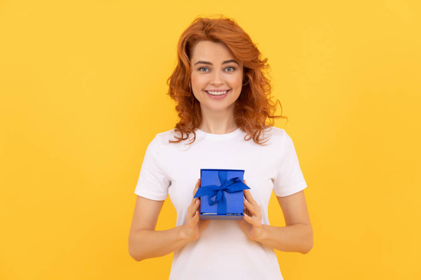 cheerful girl with box on yellow background. boxing day. present and gifts buy. - Photo, Image