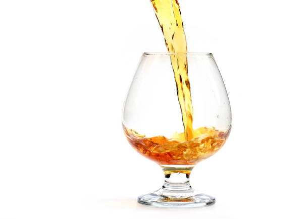 amazingly beautiful curls of a strong alcoholic drink when poured into a glass - Φωτογραφία, εικόνα