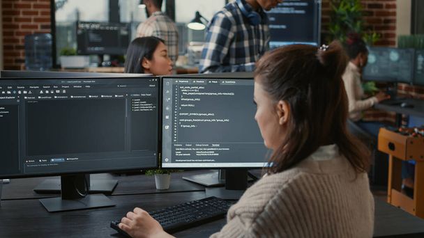 Programmatore di software che scrive codice di fronte a più schermi del computer - Foto, immagini