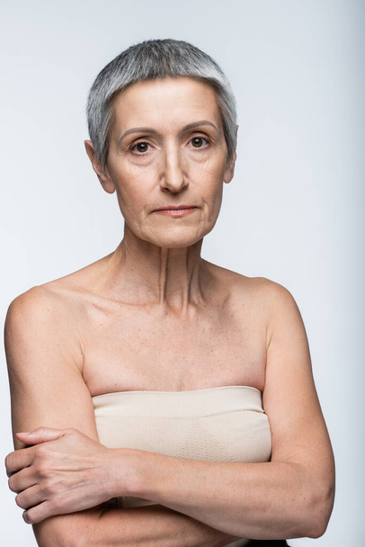 middle aged woman with bare shoulders isolated on grey - Photo, Image
