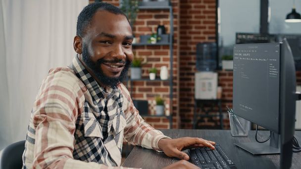 ソフトウェア開発者がコンピュータキーボードでプログラミングコードを入力頭を回し笑顔 - 写真・画像
