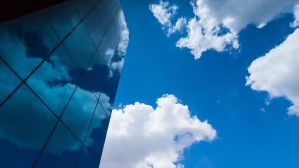 時間の経過、青空と流れる雲を反映したガラスで覆われた超高層ビルを見上げて - 映像、動画