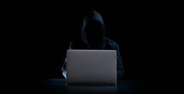 サイバー攻撃ハッカーの概念。インターネットのウェブハック技術。ハッカーの手の中のぼやけたデジタルノートパソコンは、グリッチ効果で黒に隔離されています。データ保護、安全なインターネットアクセス、サイバーセキュリティ - 写真・画像