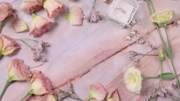 Main met JUSTE MARRIED carte sur une table en marbre près de fleurs roses gros plan  - Séquence, vidéo