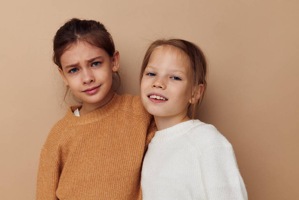 two cute little girls hug friendship lifestyle beige background - Photo, image