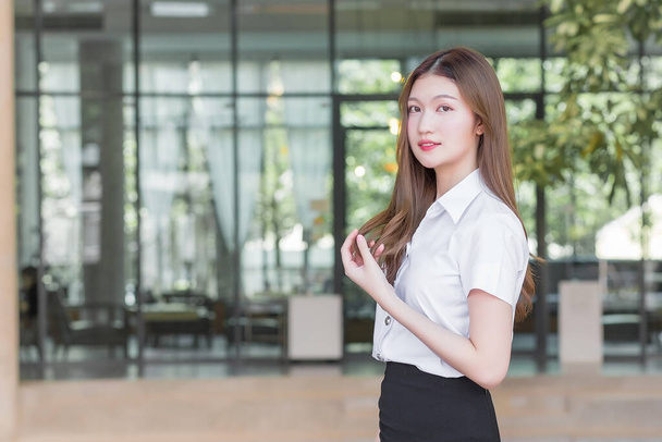 Retrato de un estudiante tailandés adulto en uniforme de estudiante universitario. asiático hermosa mujer de pie sonriendo felizmente en la universidad - Foto, imagen