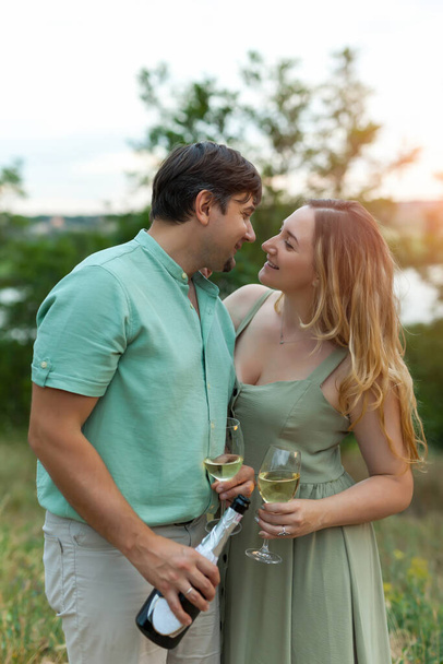 Pareja romántica brindando copas de vino al aire libre. Hermosa mujer tintineo copa de vino con su hombre. - Foto, imagen