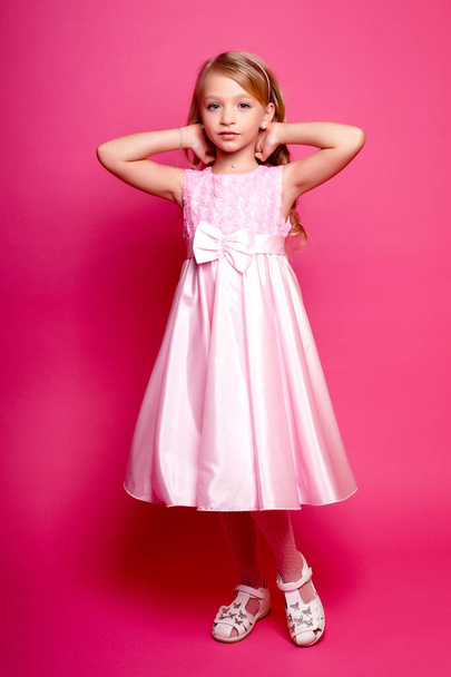 Pretty young kid girl  in pink dress.Isolated studio shot - Fotó, kép