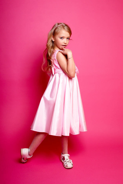 Pretty young kid girl  in pink dress.Isolated studio shot - 写真・画像