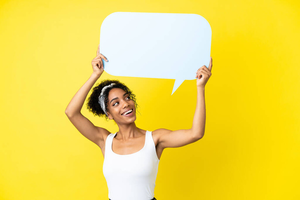 Young african american woman isolated on yellow background holding an empty speech bubble - Foto, Bild