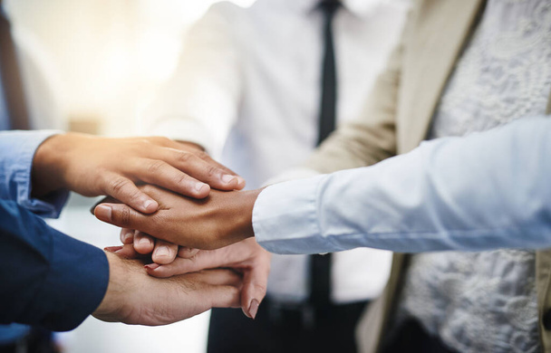 Its hard to beat someone who wont give up. Cropped shot of a group of businesspeople putting their hands together in unity. - Fotografie, Obrázek