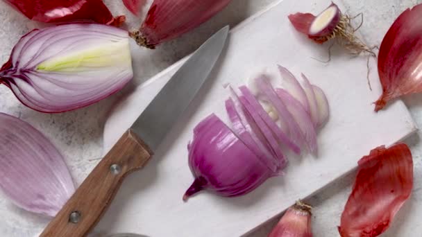 Κομμένο φρέσκο κρεμμύδι Tropea σε μια ξύλινη σανίδα από κοντά, έννοια του μαγειρέματος στο σπίτι στην κουζίνα - Πλάνα, βίντεο