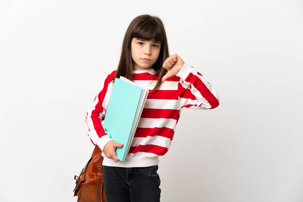 Kisdiák lány elszigetelt fehér háttér mutatja hüvelykujj le negatív kifejezés - Fotó, kép