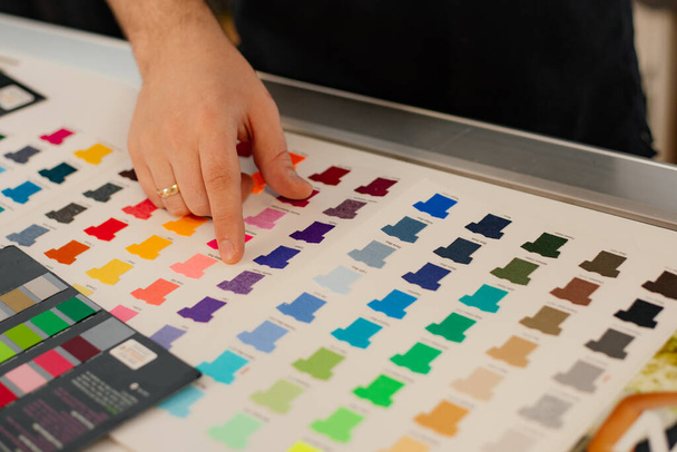 Обрізане кільце рук людини, вибираючи фіолетові шаблони багатобарвної реклами Футболки палітра плівок мембрани. Виробництво тканин
 - Фото, зображення