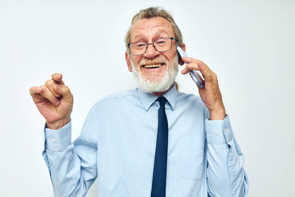Senior grey-haired man talking on the phone business work isolated background - Foto, Imagen
