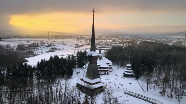 Légi drón kilátás a Peri-Sapanta kolostor télen, Románia. Fő templom és egy épület, látogatók, csupasz erdő és hó körül - Felvétel, videó