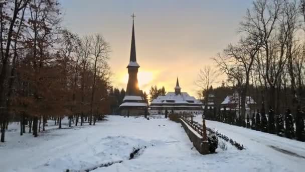 Légi drón kilátás a Peri-Sapanta kolostor télen, Románia. Fő templom és egy épület, csupasz erdő és hó körül - Felvétel, videó