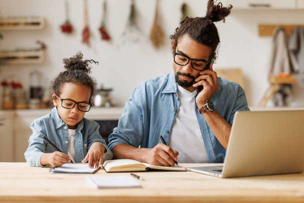 Mladý africký americký táta pracuje dálkově na notebooku s dítětem syn doma - Fotografie, Obrázek